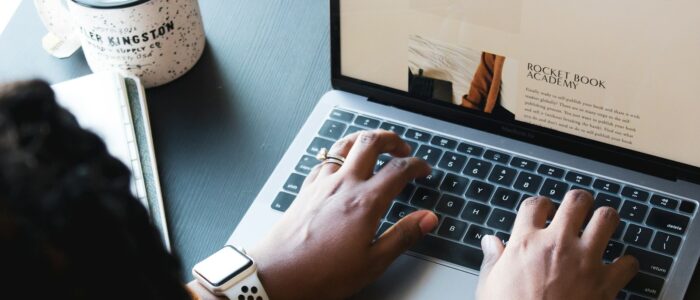 person using macbook pro on black table