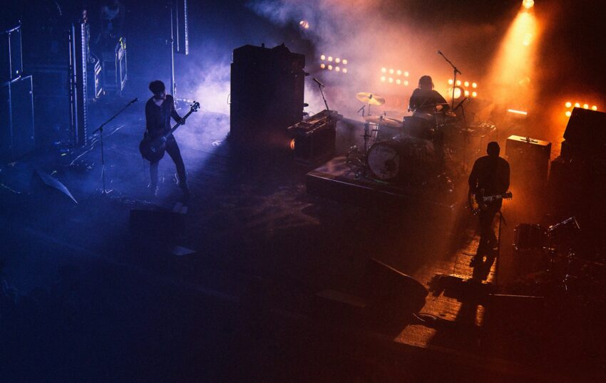 three people playing assorted instruments on stage