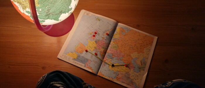 world map near desk globe on brown wooden panel